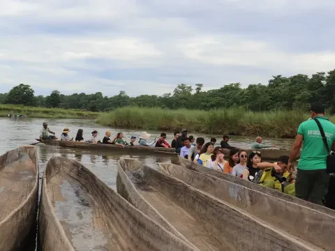 Traditional canoe ride on the Rapti River during a Chitwan Jungle Safari Tour in Nepal.