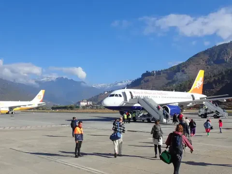 Paro International Airport surrounded by green Himalayan mountains in Bhutan.