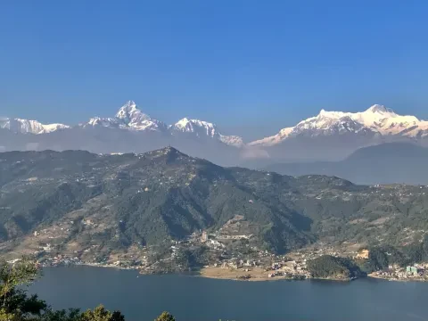 Himalayan mountains reflected in the calm waters of Phewa Lake in Pokhara, Nepal.