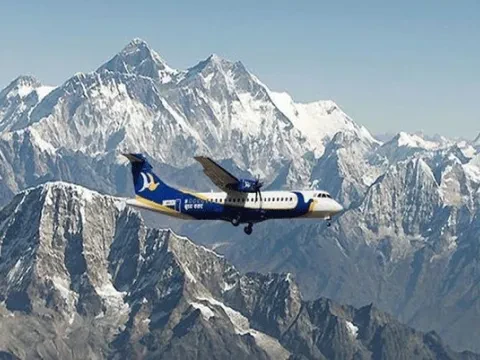 Airplane flying beside the snow-covered Himalayan range during an Everest mountain flight in Nepal.