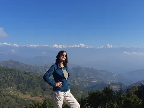 Tourist posing with the Himalayan mountain range in the background in Nepal.