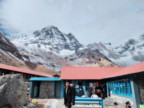 Mountain lodge at Annapurna Base Camp surrounded by towering Himalayan peaks in Nepal.