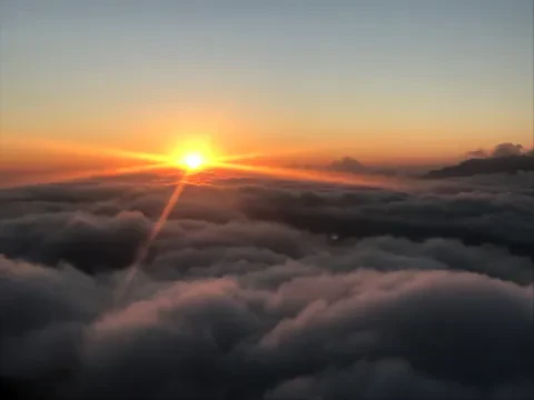 Colorful Poon Hill sunrise above a sea of clouds and mountain valleys .