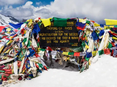 Colourful prayer flags at Thorong La Pass on the Annapurna Circuit Trek in Nepal.