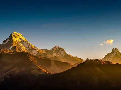 Golden sunrise light highlights the majestic Annapurna and Machhapuchhre peaks.