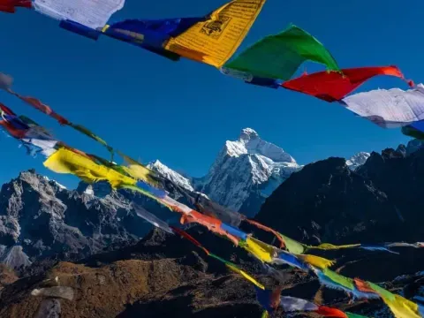 Colourful prayer flags fluttering against the majestic Kanchenjunga mountain landscape.