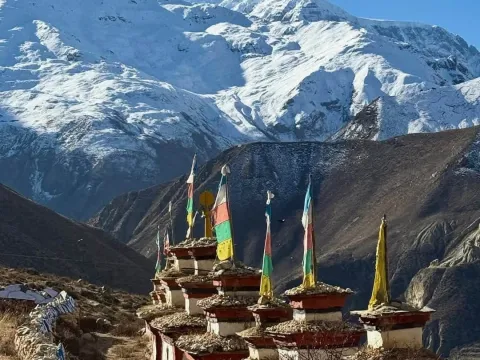 Buddhist stupa along the Nar Phu Valley Trek with Annapurna mountains.