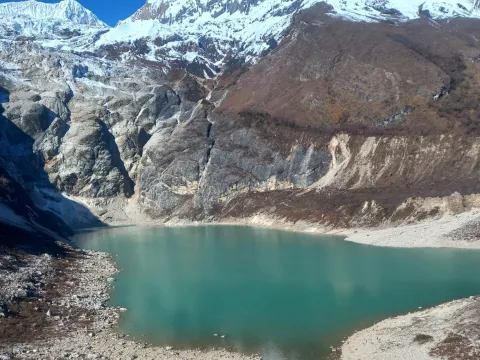 Birendra Tal glacial lake surrounded by snow-capped mountains on the Manaslu Circuit Trek .