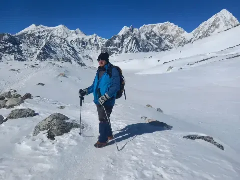 Trekker walking through snow near Larke Pass on the Manaslu Circuit Trek.