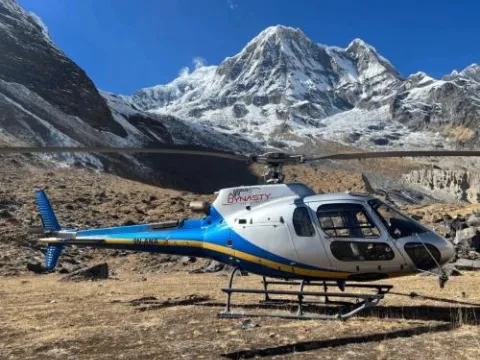 Helicopter landing at Annapurna Base Camp with Himalayan mountains.