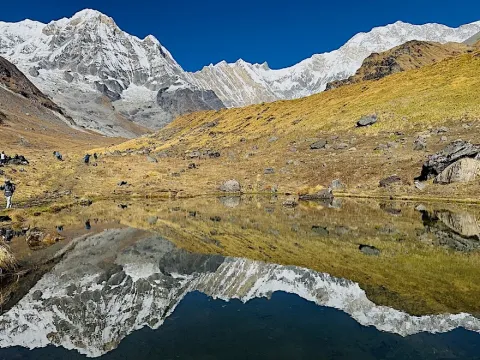 Annapurna mountains reflected in a clear lake along the Annapurna Base Camp Trek in Nepal .