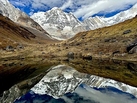 Annapurna mountains reflected in a calm lake along the Annapurna Base Camp Trek in Nepal.