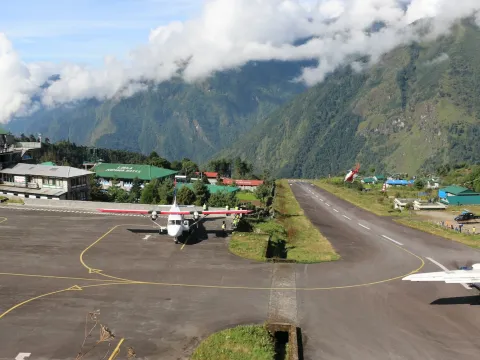 Lukla Airport in Nepal with mountains surrounding the runway.