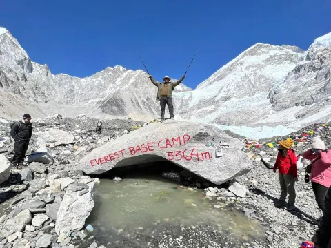Everest Base Camp rock surrounded by dramatic Himalayan mountains in Nepal.