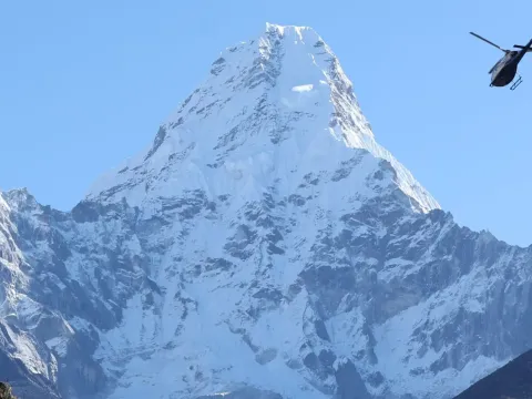 Helicopter flying with Mount Ama Dablam in the background in the Everest region of Nepal.
