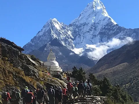 Trekkers heading toward Island Peak with Mount Ama Dablam in the foreground.