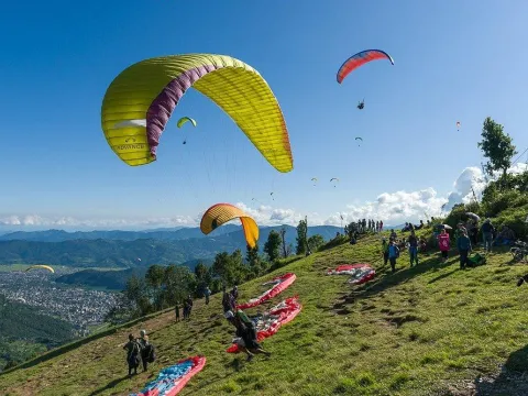Paragliders preparing for take-off from Sarangkot overlooking Pokhara Valley, Nepal.