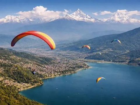 Colourful paragliders floating above Pokhara Valley and Phewa Lake in Nepal.