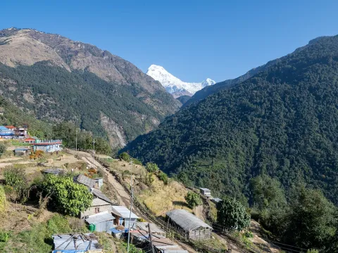 Jeep passing through Ulleri village with scenic Annapurna mountain views, Nepal.