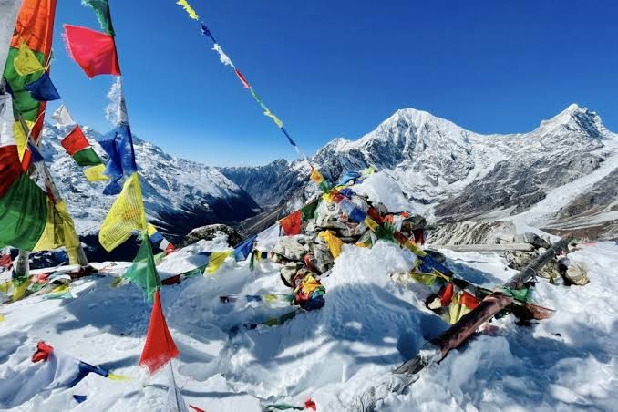 Trekker capturing stunning views of Langtang Lirung, Kyanjin Gompa, glaciers, prayer flags, and the Himalayan landscape during the Langtang Valley Trek in Nepal.