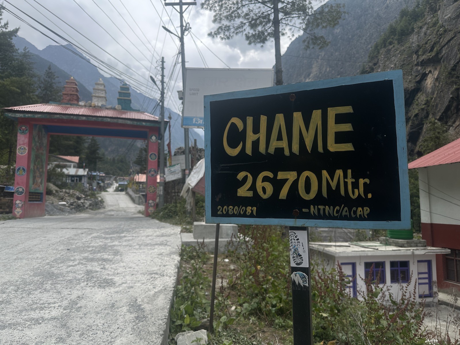 Chame village on the Annapurna Circuit Trek with traditional stone houses, colorful prayer flags, pine forests, the Marshyangdi River, and magnificent views of Lamjung Himal and Annapurna II in Nepal.