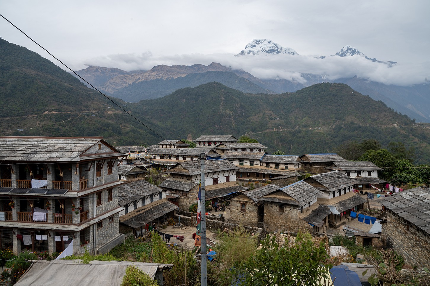 Traditional Gurung village of Ghandruk with stone houses, terraced fields, and panoramic views of the Annapurna Himalayan range in Nepal.