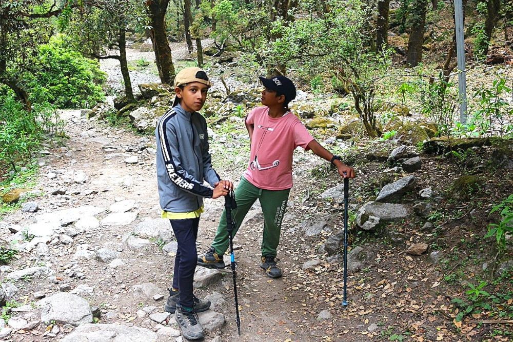 Young beginner trekkers walking through the Langtang Valley while enjoying the scenic Himalayan landscape.