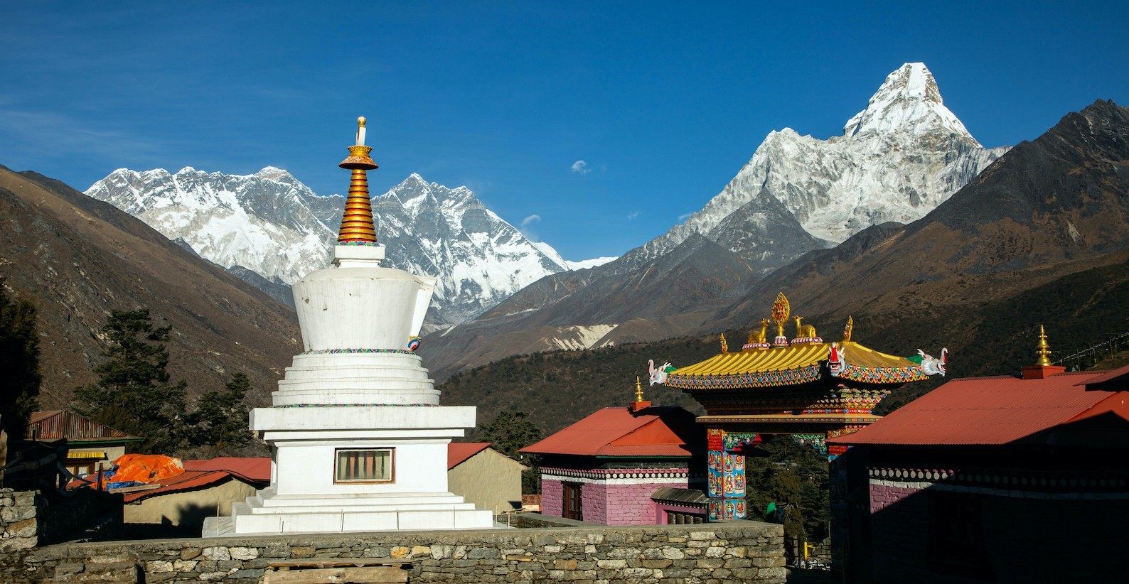 Tengboche Monastery surrounded by spectacular Himalayan mountain views, with Ama Dablam, Everest region peaks, prayer flags, and traditional Buddhist architecture under a clear alpine sky.