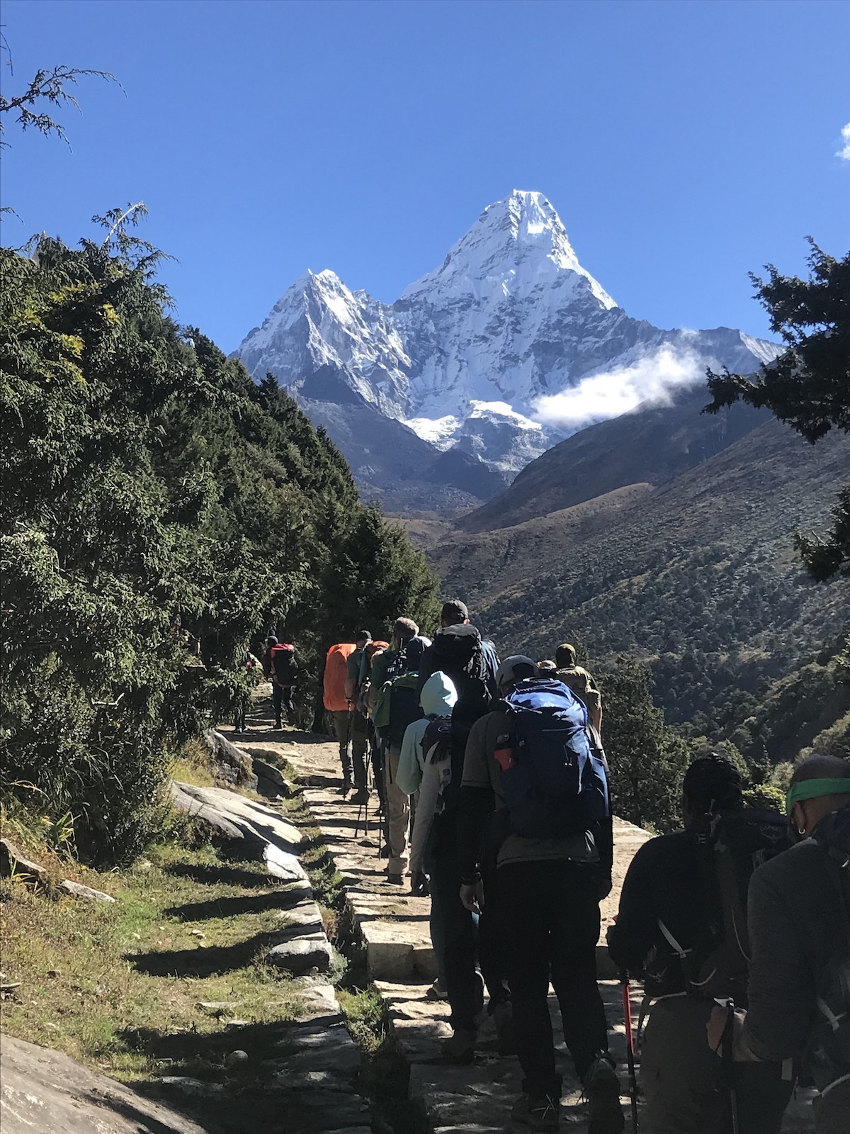 "Trekker walking along the Everest trekking trail toward Ama Dablam with spectacular Himalayan mountain scenery in the Khumbu region of Nepal."  