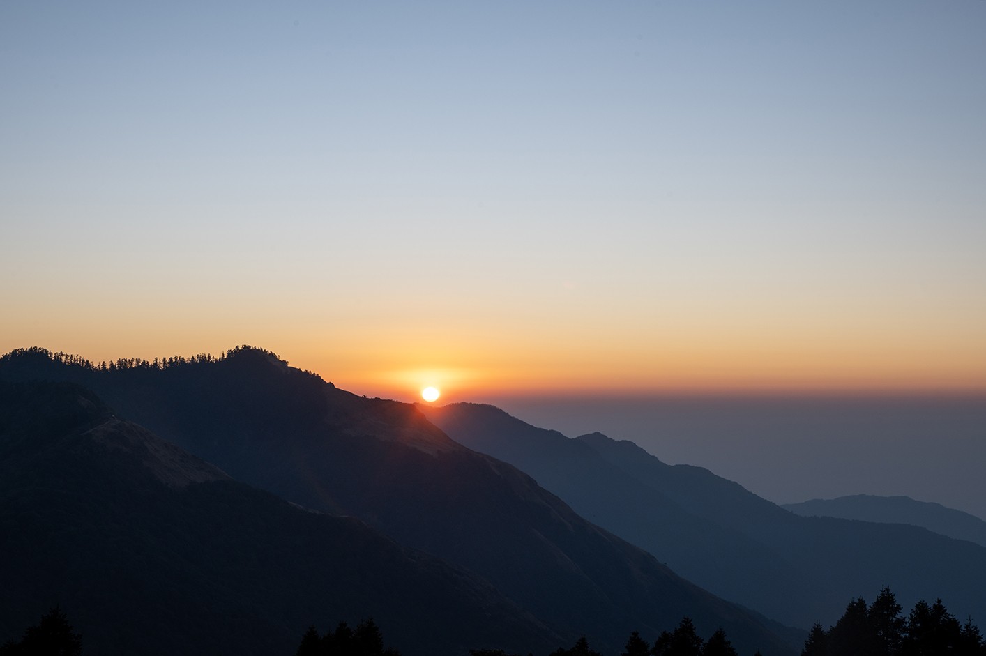 Sunrise from Poon Hill with golden light illuminating the Annapurna and Dhaulagiri mountain ranges in Nepal.