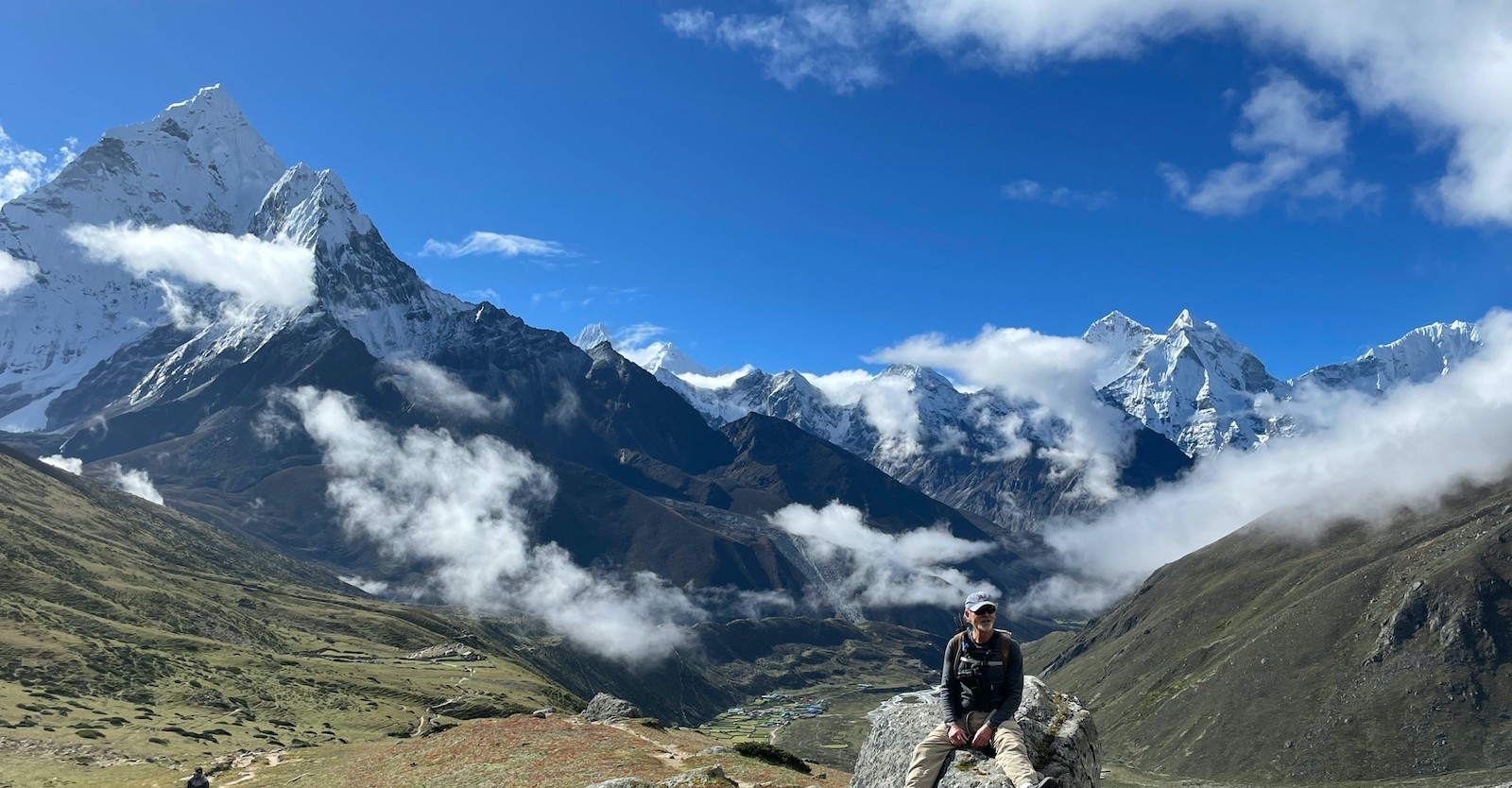 Green Pheriche Valley in September with Mount Ama Dablam, surrounding Himalayan peaks, and light clouds under a clear sky on the Everest Base Camp Trek.