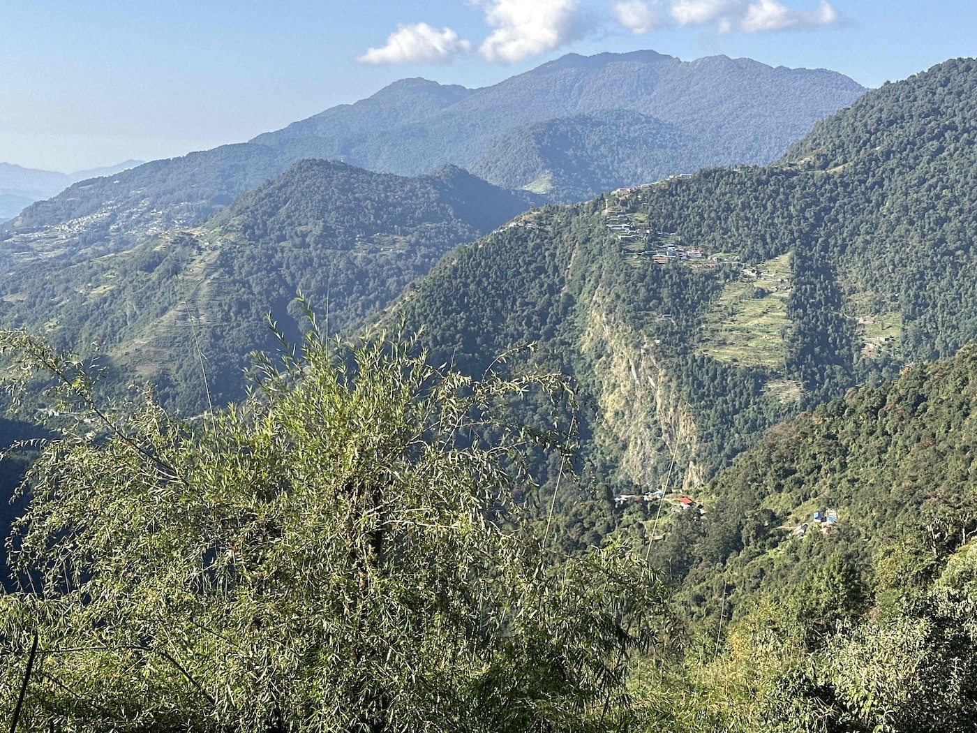 Panoramic view from the trail between Sinuwa and Jhinu Danda showing deep valleys, traditional mountain villages, terraced hillsides, forests, and scenic Annapurna foothill landscapes.