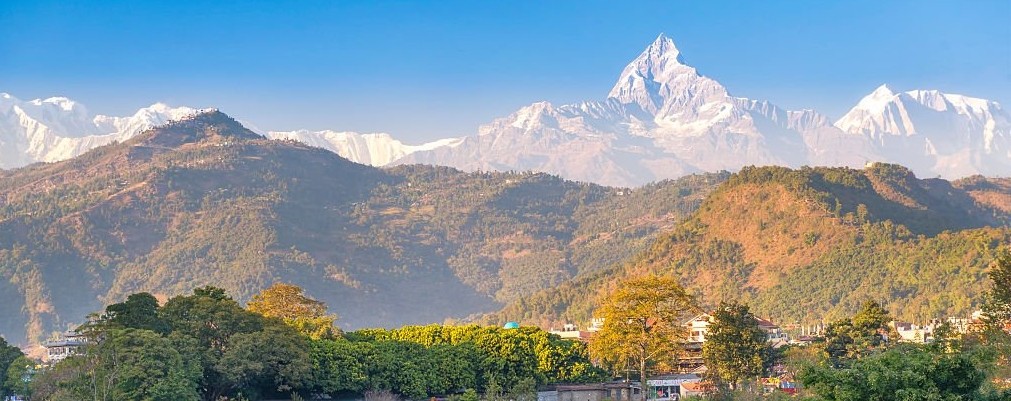 Pokhara city with stunning views of the Annapurna mountain range and Machhapuchhre (Fishtail Mountain), featuring Phewa Lake, colorful lakeside scenery, and the beautiful Himalayan backdrop.
