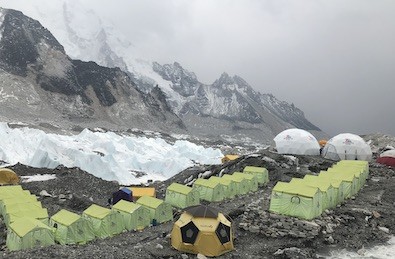 Everest Base Camp with colorful expedition tents, climbers preparing for the summit, the Khumbu Glacier, and towering Himalayan peaks under clear blue skies.