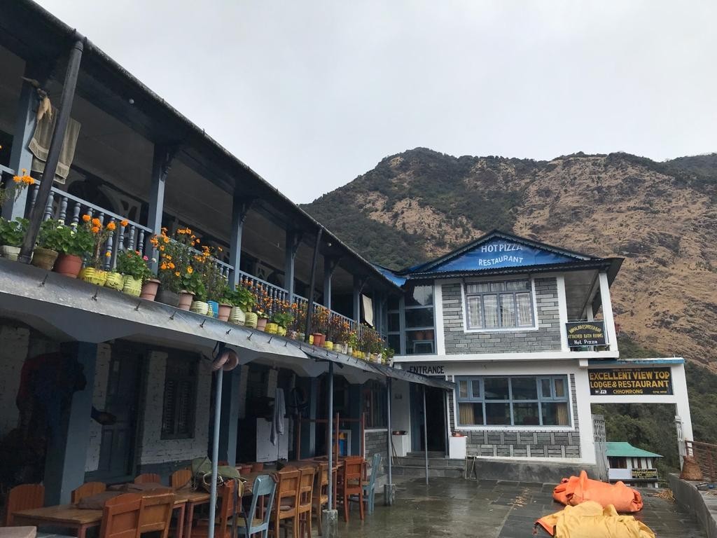 Traditional mountain lodge on the Annapurna Base Camp Trek, surrounded by Himalayan peaks and alpine scenery.