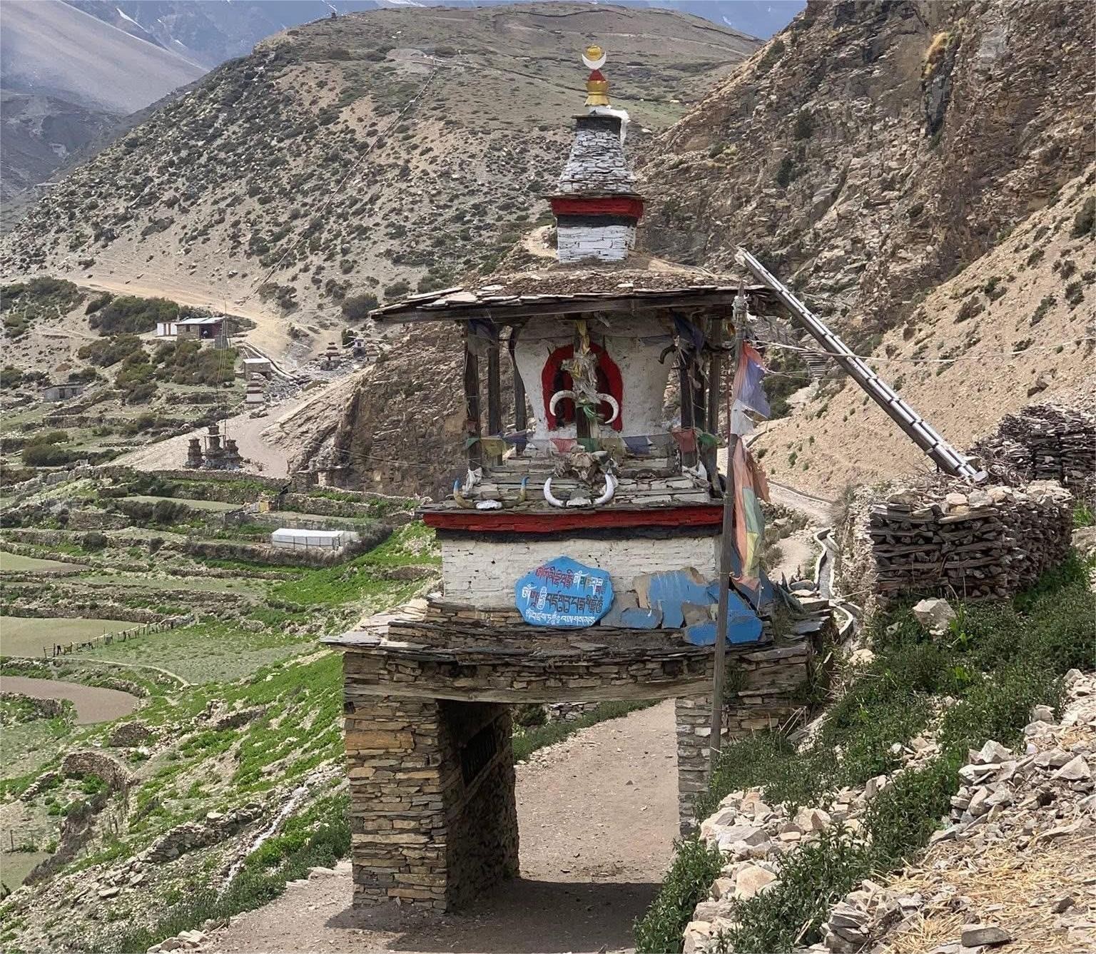 Traditional stupa gate in Nepal Himalayas at village entrance in Nar Phu Valley or Manaslu region showing Buddhist architecture, prayer symbols and mountain trekking route