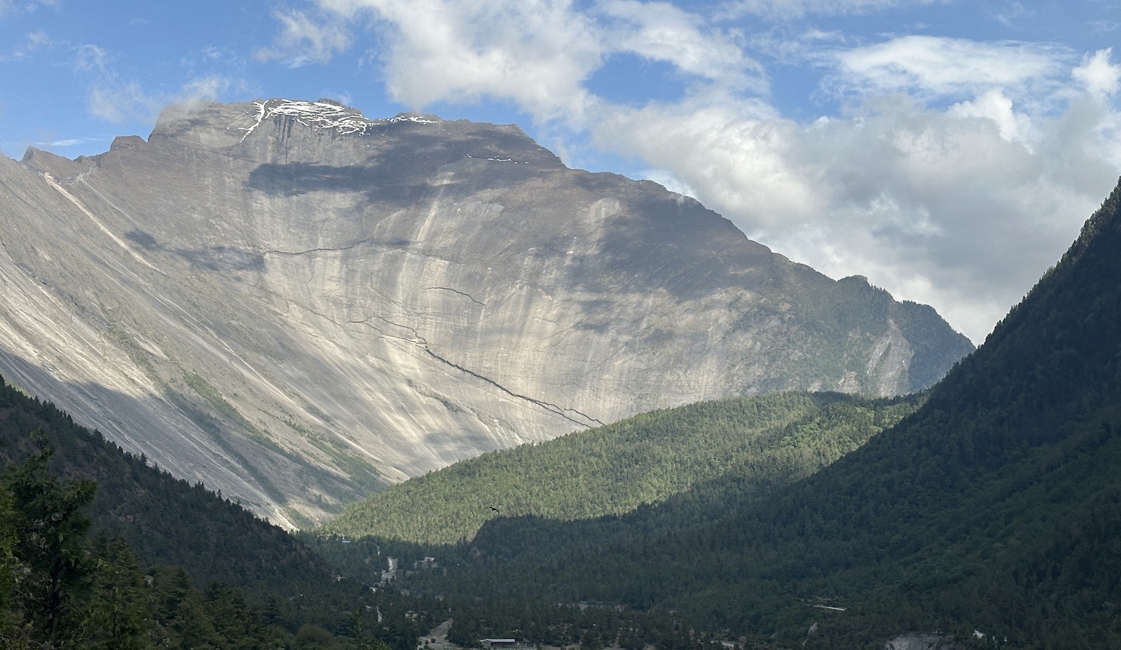 Gateway entrance on a Himalayan trekking route in Nepal featuring a large dramatic rock formation, surrounding deep valley views, and rugged mountain landscape along the trekking trail.