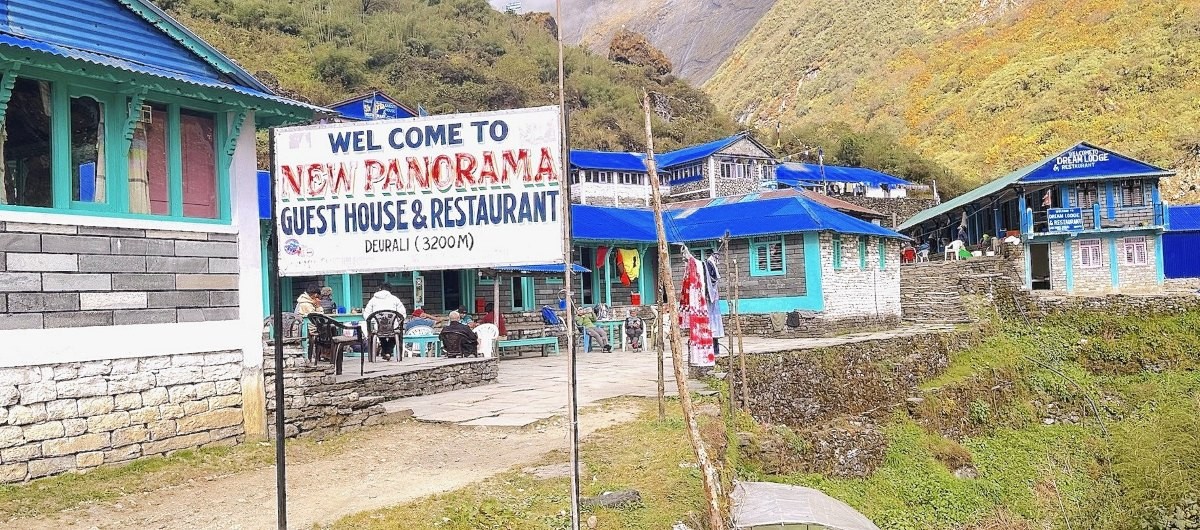 Deurali settlement on the Annapurna Base Camp trekking route, surrounded by steep Himalayan valley walls, rocky slopes, and snowy alpine landscape. 