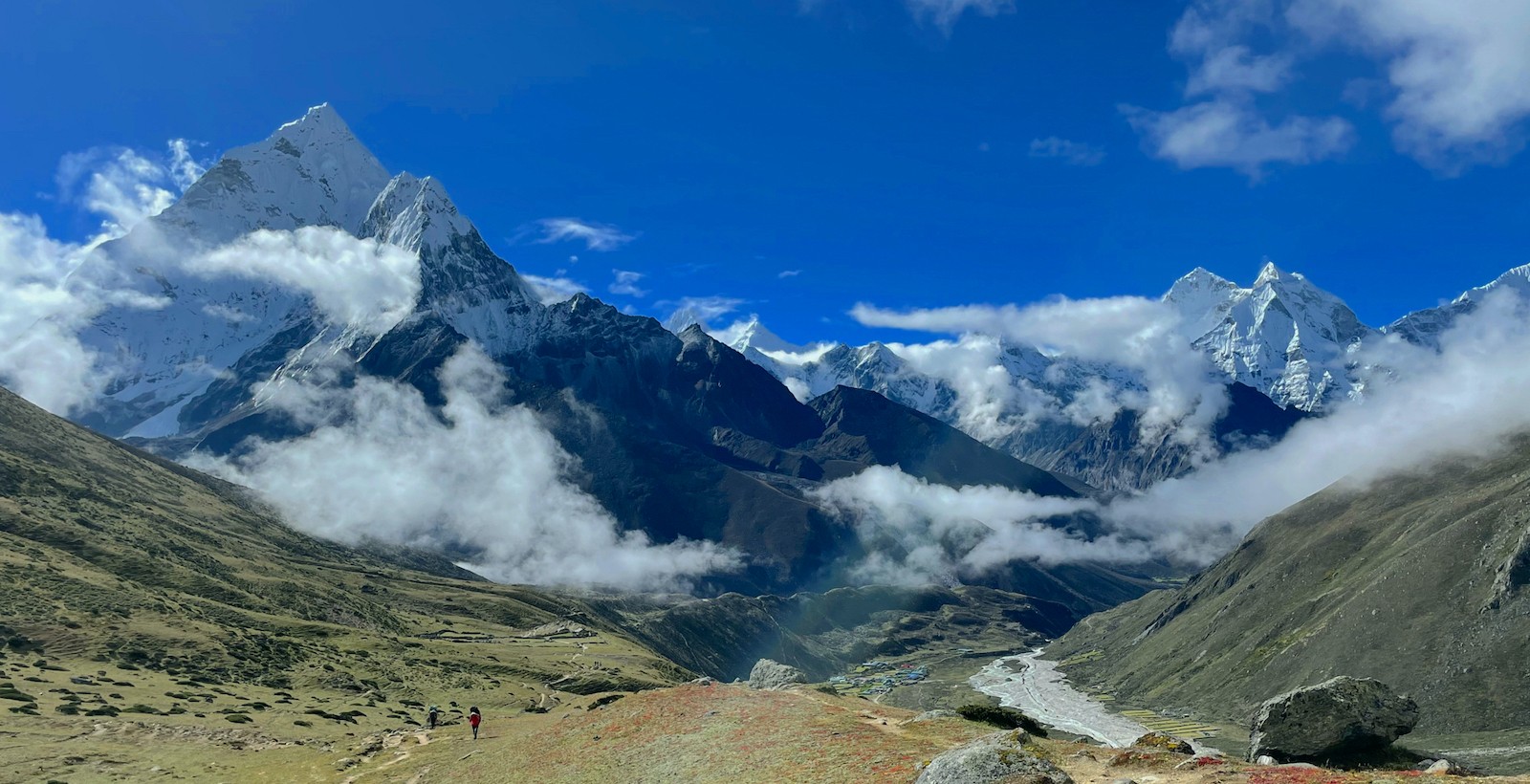 Panoramic view of Pheriche Valley with Ama Dablam, Cholatse, Taboche, and surrounding snow-capped Himalayan peaks rising above the Imja Khola under a clear blue sky.
