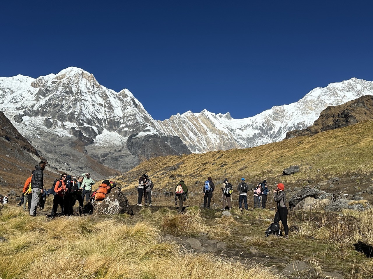 Trekkers hiking through the Annapurna Base Camp trail in November with crisp skies and snow-covered Himalayan peaks.