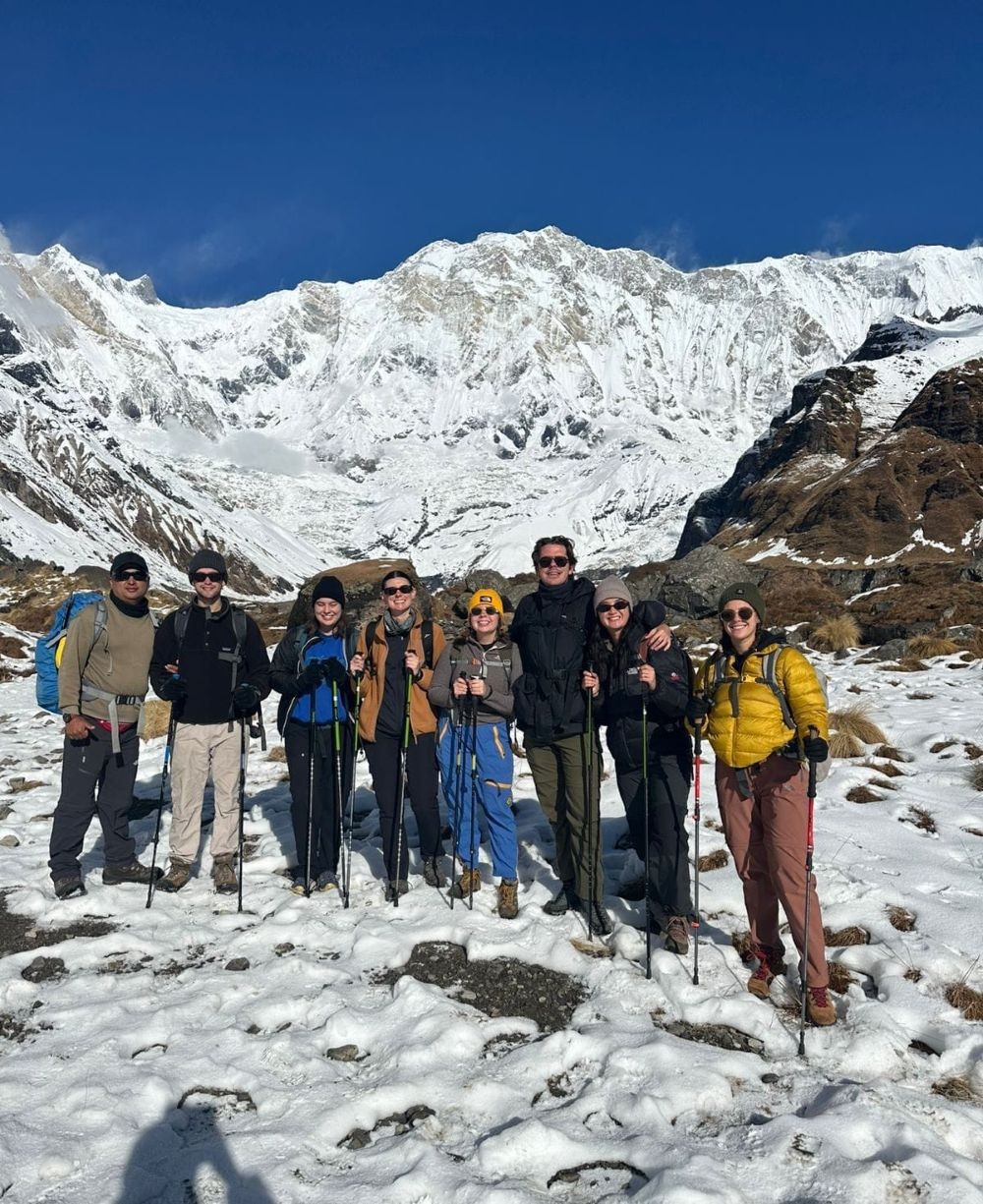 Winter Annapurna Base Camp Trek with trekkers standing in deep snow beneath snow-covered Himalayan peaks.