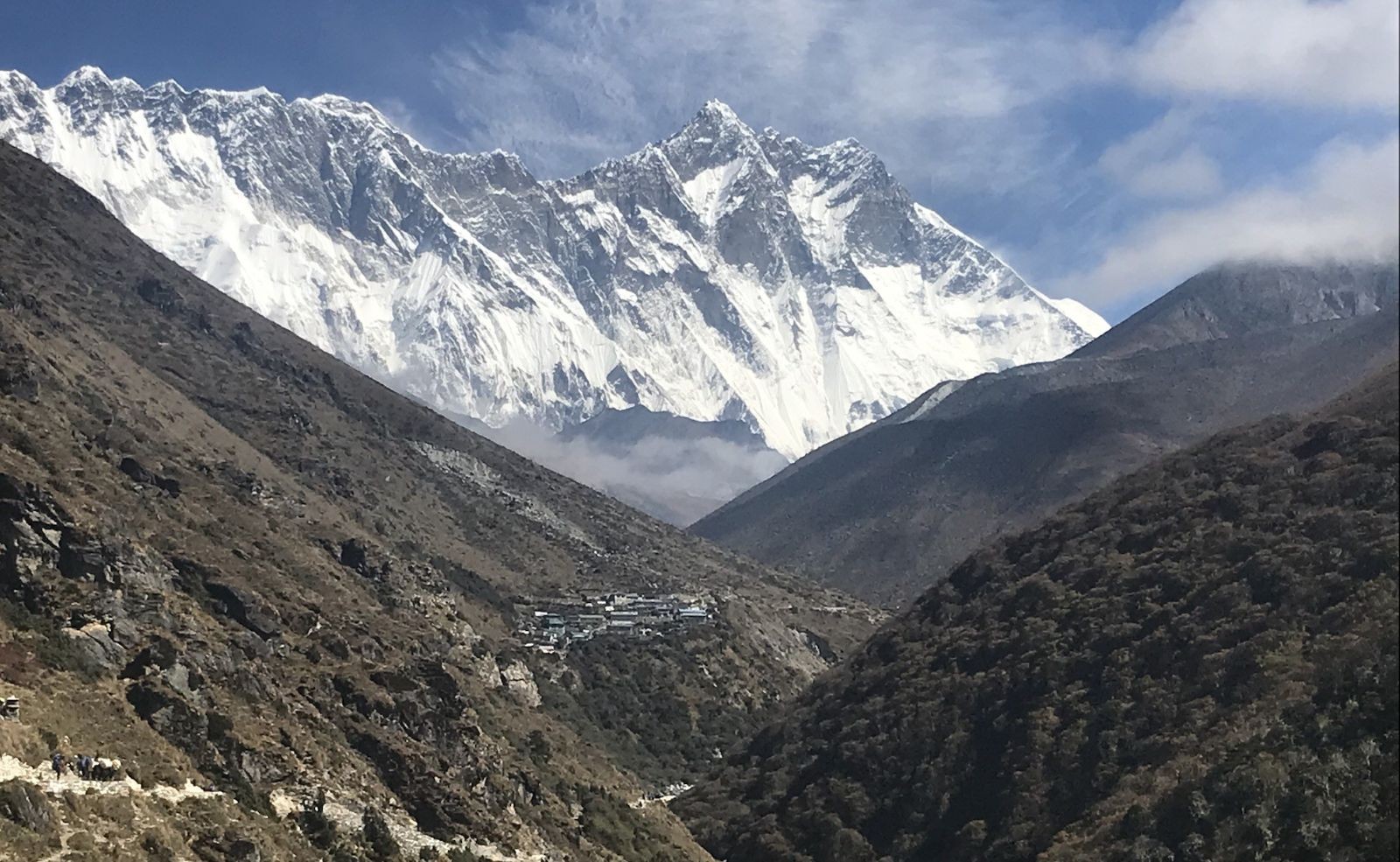 Trekkers following the Imja River Valley from Tengboche to Dingboche with snow-capped Himalayan peaks in Nepal.