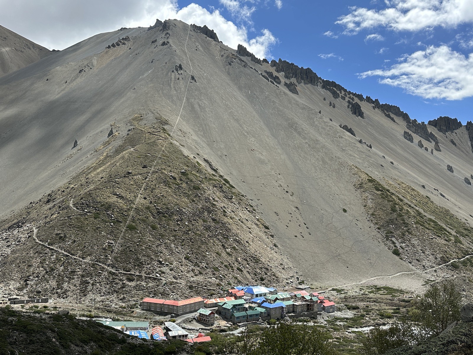 Tilicho Base Camp lodges at the foot of rugged Himalayan mountains on the Annapurna Circuit Trek in Nepal, surrounded by dramatic rocky cliffs and alpine landscapes.