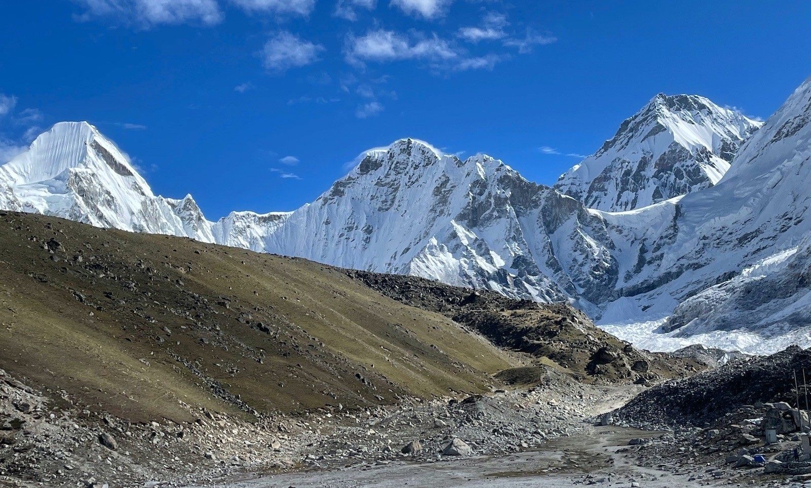 Trekkers hiking the Everest Base Camp Trail in October under clear blue skies, with dry paths, colorful autumn landscapes, and panoramic views of Mount Everest, Ama Dablam, Lhotse, and Nuptse. 