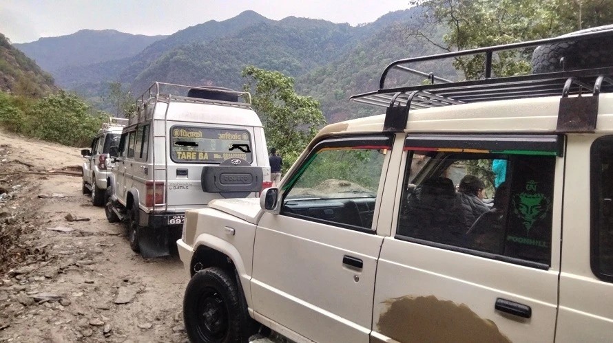4WD jeep driving along the rugged mountain road through the Solu-Khumbu region toward Surke, a scenic overland route to the Everest Base Camp Trek in Nepal.