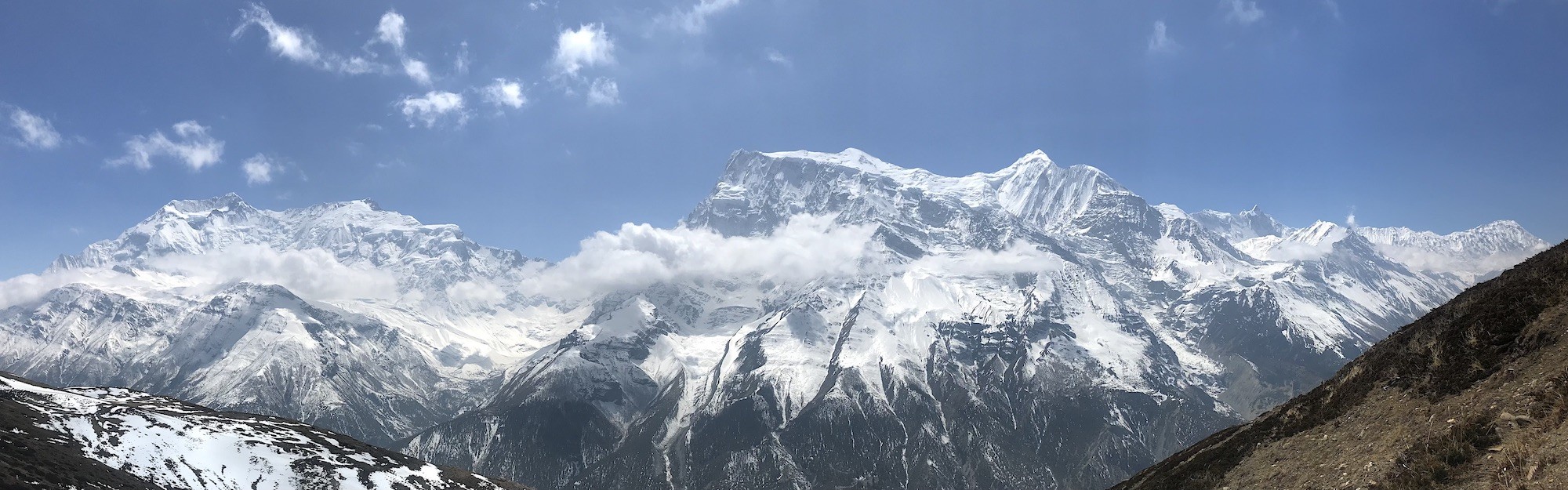 "Annapurna Circuit Trek in autumn featuring colourful landscapes, crystal-clear skies, snow-capped Himalayan peaks, traditional mountain villages, and trekkers crossing scenic high-altitude trails in Nepal."