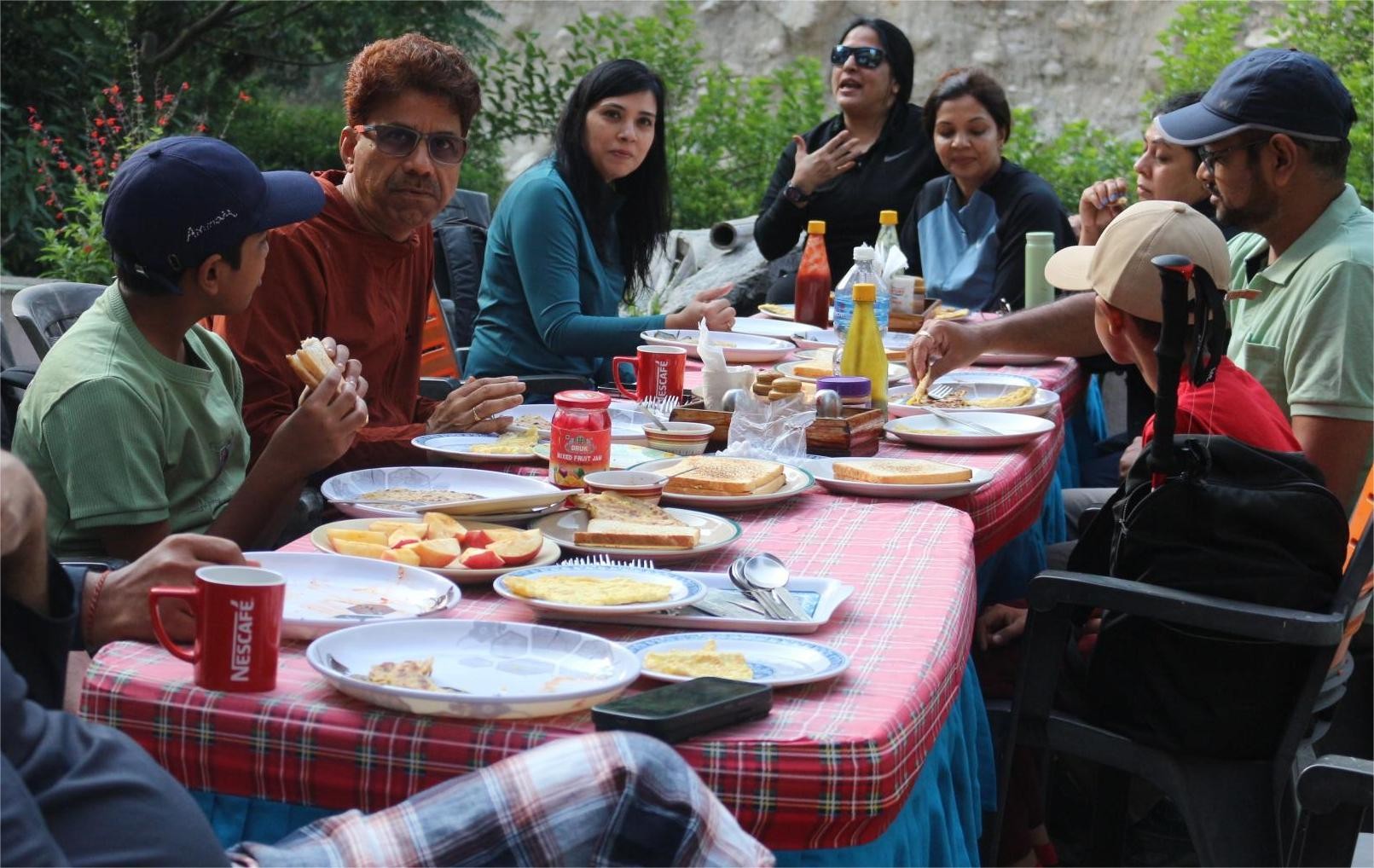 Haven Holidays guests enjoying lunch in Langtang Valley at a local teahouse, surrounded by Himalayan mountains, traditional lodges, and beautiful alpine scenery.