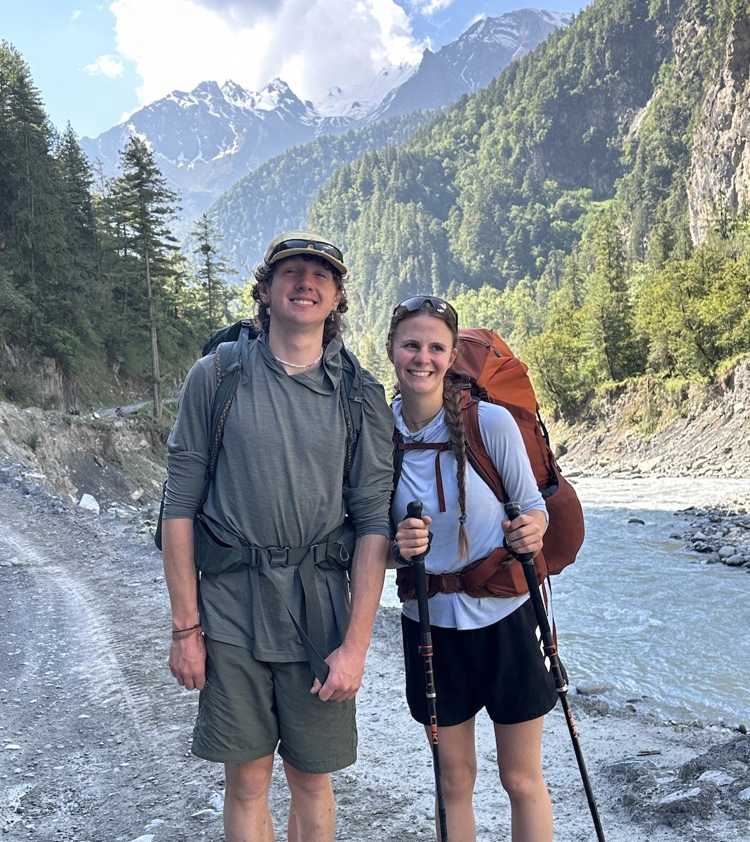 Trekker on Annapurna Circuit Trek in lower valley of Nepal walking in comfortable weather and layered trekking clothes”