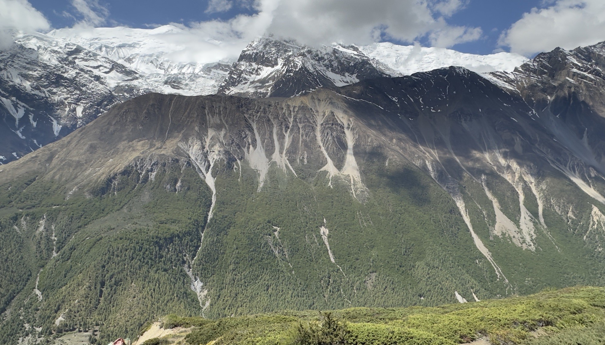 Dry and well-maintained Annapurna Circuit trail in October with clear blue skies, dusty mountain paths, colorful prayer flags, and stunning Himalayan peaks under stable post-monsoon weather.