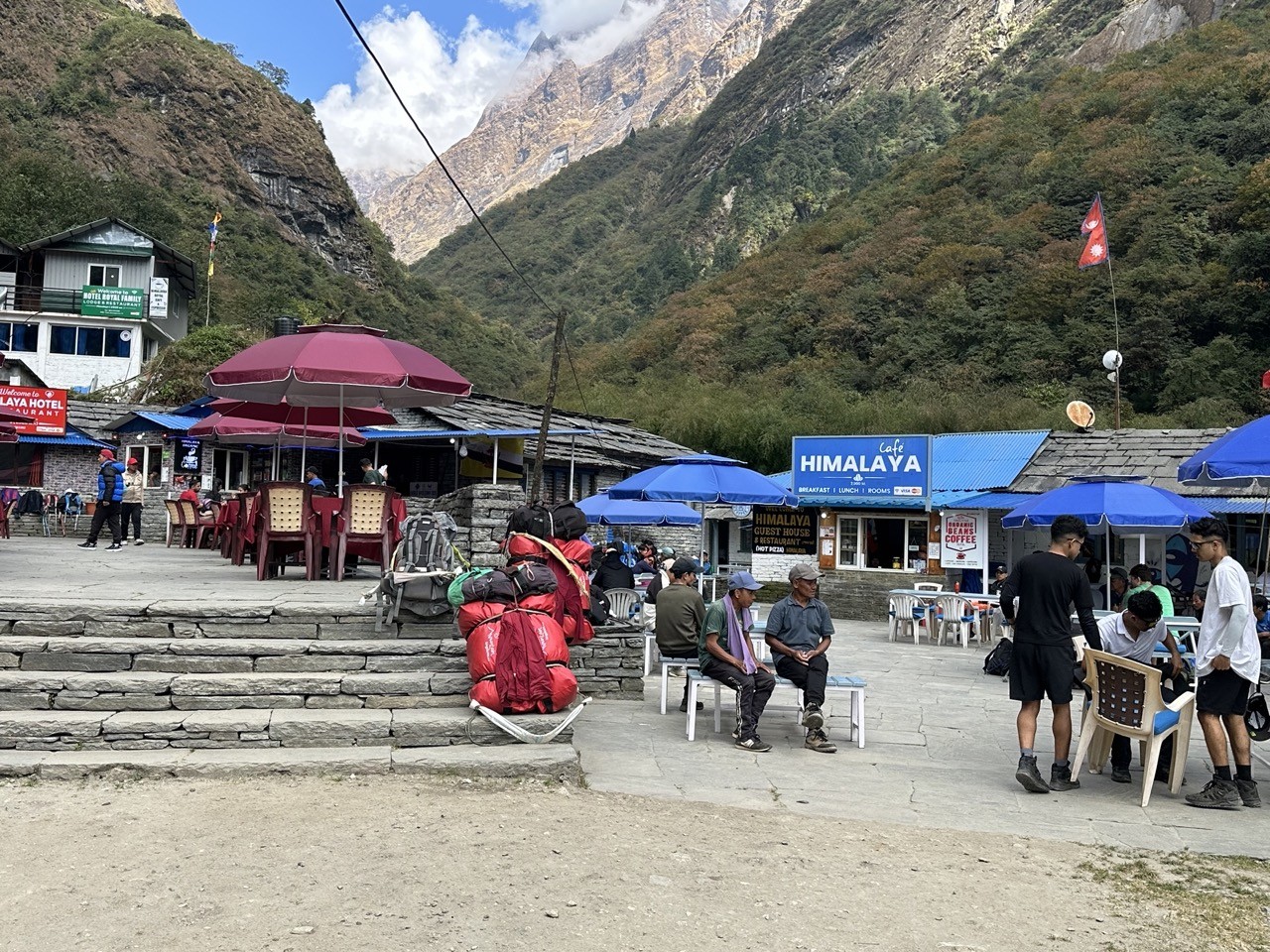 Crowded teahouse area with trekkers, porters, and backpacks during the Annapurna Base Camp autumn trekking season.